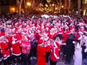 Milhares de pessoas dançam em trajes de Papai Noel na festiva festa de rua de Palma