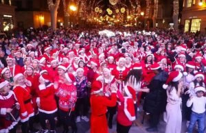Milhares de pessoas dançam em trajes de Papai Noel na festiva festa de rua de Palma