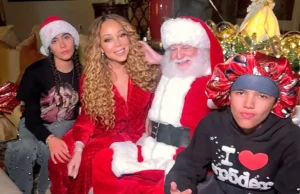 Mariah Carey comemora o Natal como gêmeas, 14 anos, elevando-se sobre ela em foto festiva