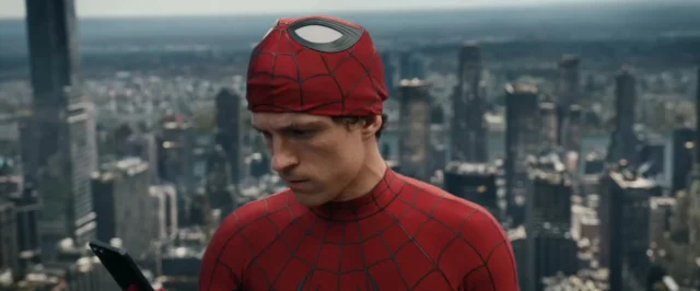 Peter-Parker-Tom-Holland-looking-at-his-phone-with-New-York-City-in-the-background-in-the-Marvel-fil.webp