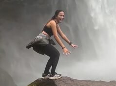 Mulher luta hilariamente para posar para foto perto de uma enorme cachoeira nas Filipinas